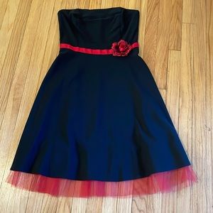 Black strapless dress with red sash, rose, and lace